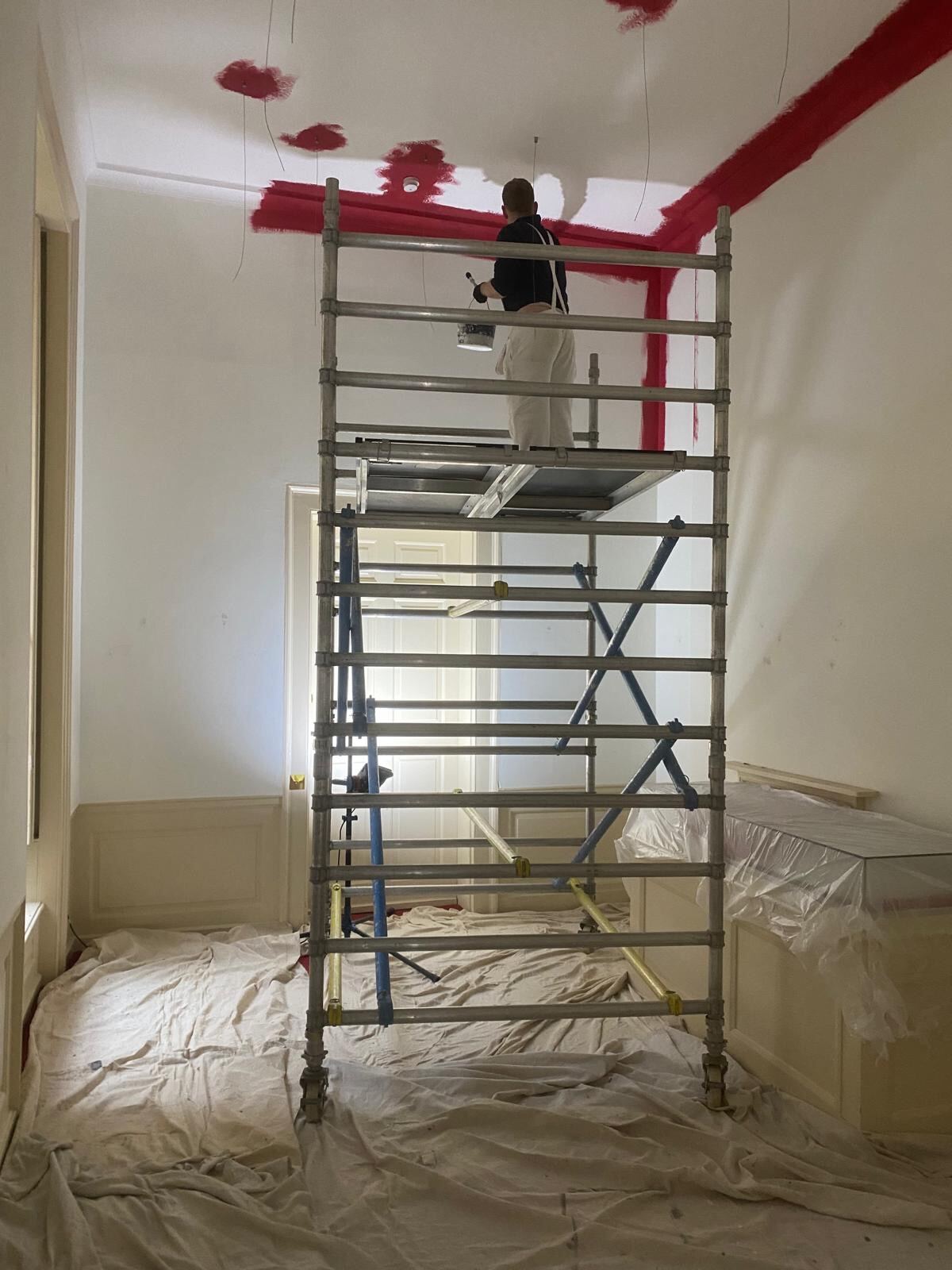 Brierty decorator cutting in heritage red ceiling line from mobile scaffold tower at Blenheim Palace