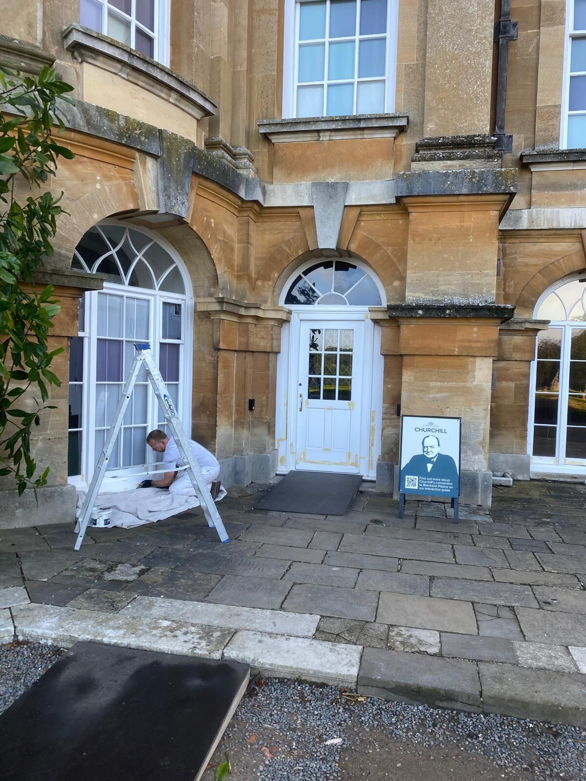 Brierty decorator preparing window frames beside the Churchill exhibition entrance at Blenheim Palace